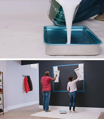 A couple is painting a white rectangle on the wall to be used for a gallery wall