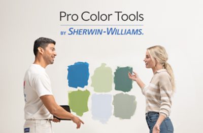 A contractor and a homeowner discussing paint samples on a wall.