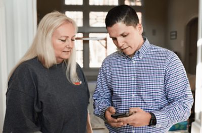 Person showing another person their mobile phone with Project Bids.