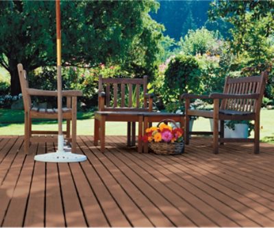 A stained deck with stained wooden outdoor furniture.