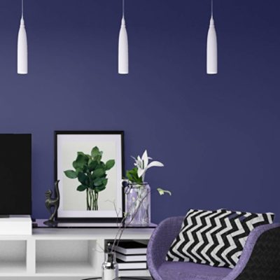A modern purple upholstered chair near a white console table holding a TV in a room painted a deep purple.