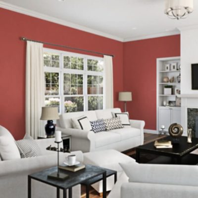 A bold red living room with white trim and white furniture.