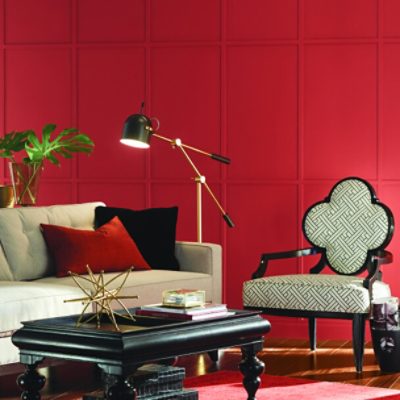 A bright red sitting area with black and white furniture and brass accents.