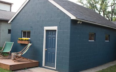 A photo of a brick garage freshly painted blue.