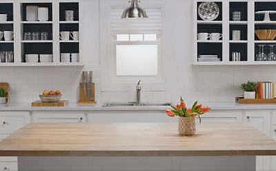 A kitchen painted white with the cabinet doors removed and painted Sherwin-Williams In the Navy SW9178 on the inside.