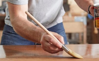 A person staining an interior surface.