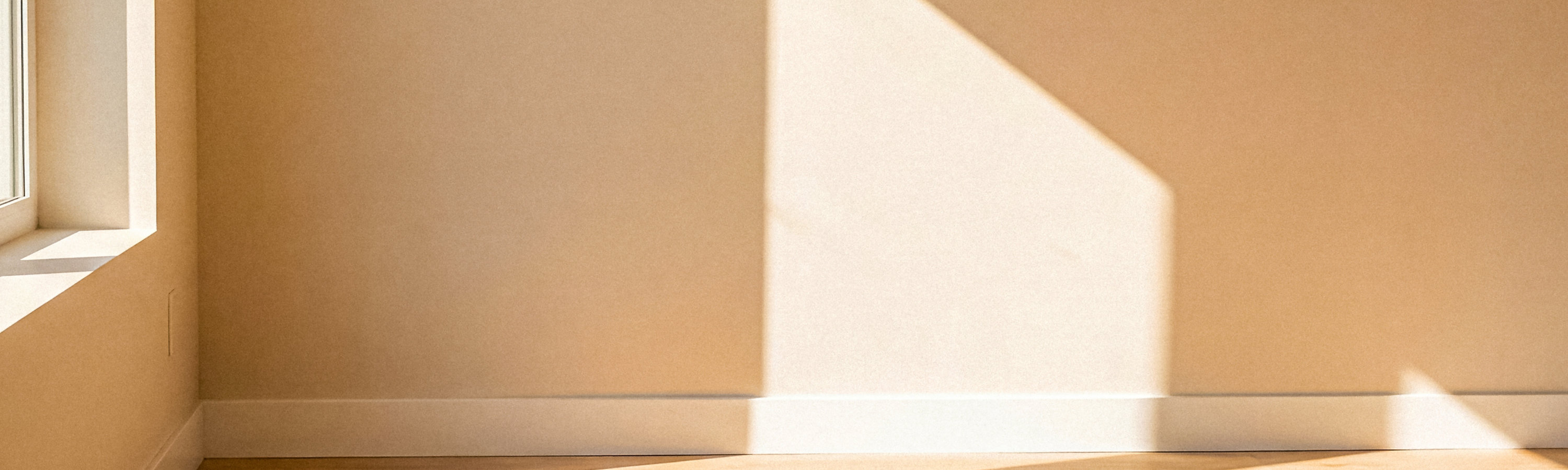 Sunlit interior with wooden flooring, showcasing a smooth finish and natural aesthetic.