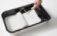 A paint tray with white paint and a paint brush.