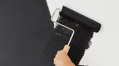 A white wall being painted black.