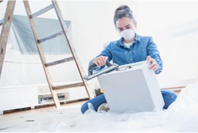 A person sanding a cabinet.