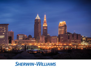 Cleveland skyline at dusk with illuminated buildings and a deep blue sky.