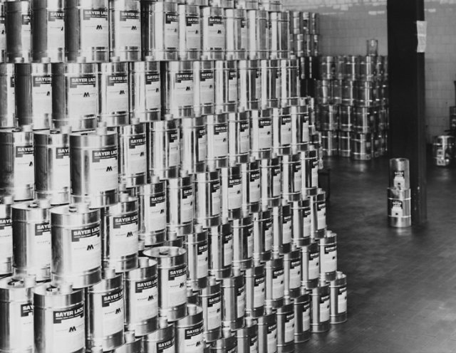 Warehouse storage of stacked Sayerlack product cans organized in rows and columns.