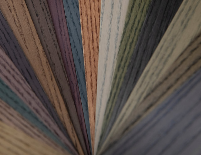 Fan-shaped display of wood samples treated with Cromalia Trends wood dyes, showcasing a wide range of natural and contemporary color tones.