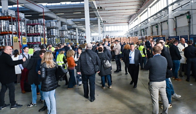 Sayerlack 70th anniversary event inside a warehouse with attendees and product displays.