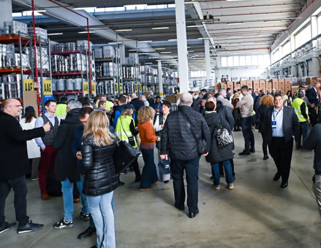 Sayerlack 70th anniversary event inside a warehouse with attendees and product displays.