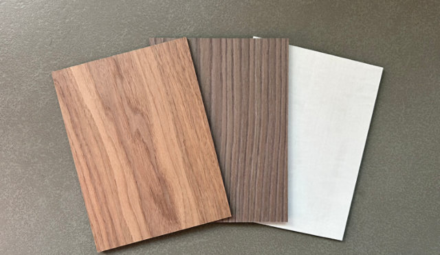 Wood samples in various shades and finishes created with stains, displayed on a rich wooden surface