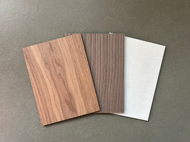 Wood samples in various shades and finishes created with stains, displayed on a rich wooden surface