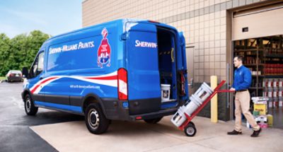A Sherwin-Williams employee loading paint into a delivery van.