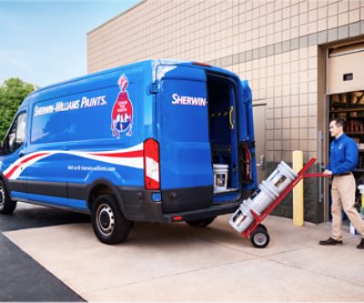 A Sherwin-Williams employee loading paint into a delivery van.