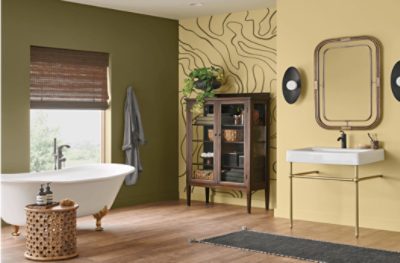 Bathroom painted in Palm Leaf SW 7735 on one wall and another in a yellow tone, footed tub, glass dresser, and sink.