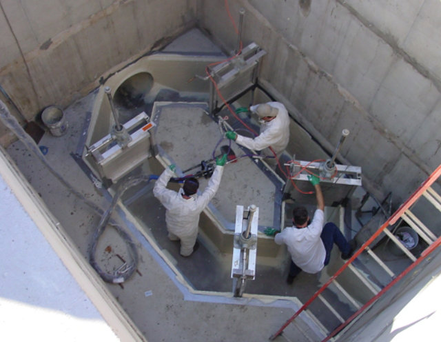 Men in lift station applying a coating