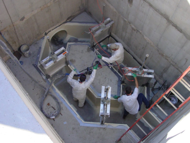 Men inside lift station applying a coating