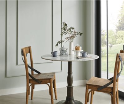A breakfast nook with a circular table, 2 chairs and French doors.