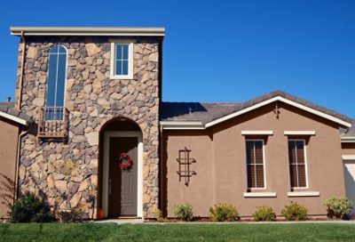 A beige and brick spanish style home with white window trim. S-W colors featured: SW 2804, SW 6105, SW 7515