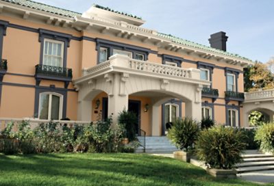 A tan spanish style home with dark painted window trim. S-W colors featured: SW 6115, SW 7565, SW 7076