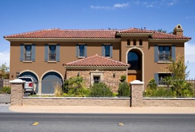 A dark beige painted spanish style home with dark blue paint trim. S-W colors featured: SW 6117, SW 6106, SW 6243