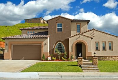 A light brown and tan spanish style home with a dome-shaped entryway. S-W colors featured: SW 6157, SW 6116, SW 6103