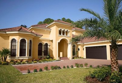 A bright yellow spanish style home with dark painted garage doors.  S-W colors featured: SW 7682, SW 6386, SW 6006