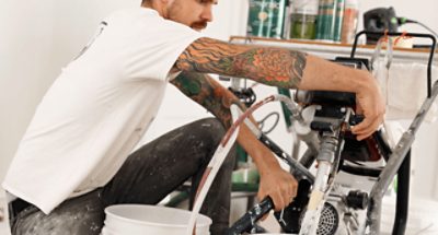A person working on spray equipment for a paint job.