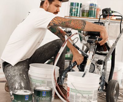 A person working on spray equipment for a paint job.