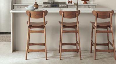 A wooden set of bar chairs in a modern kitchen. 