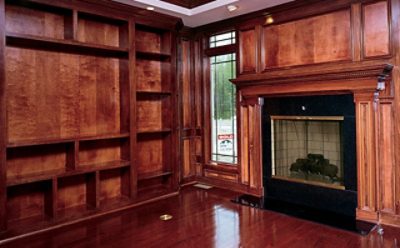 A wood stained living room with a fireplace.