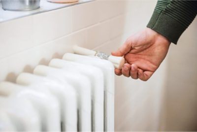 A person adjusting a radiator.