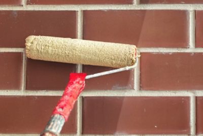 Applying primer to brick with a roller.
