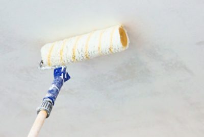 Using a roller to paint a ceiling.