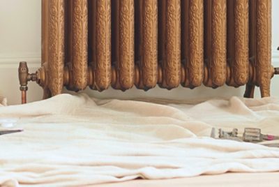 A dropcloth underneath an unpainted radiator.