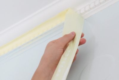 Removing painter's tape from trim.