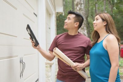 Two people looking at a garage door.