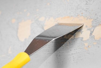 A laminated dresser drawer with a scraper and paint stripper.