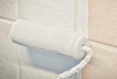 Applying primer to tile with a roller.