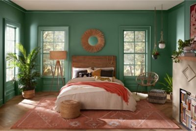 A green bedroom with wood and rust colored accents.