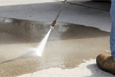 A person power washing a driveway.