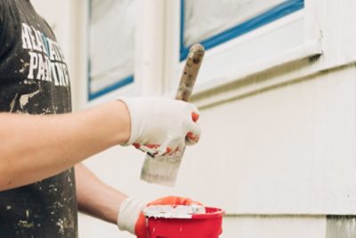 A person painting the exterior of a house.