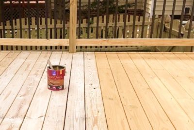 A can of deck stain on a partially finished deck.