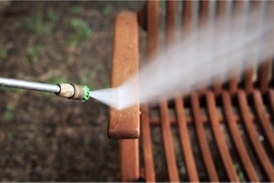A patio chair being power washed.