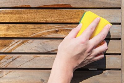 A person wiping dust off wood table.